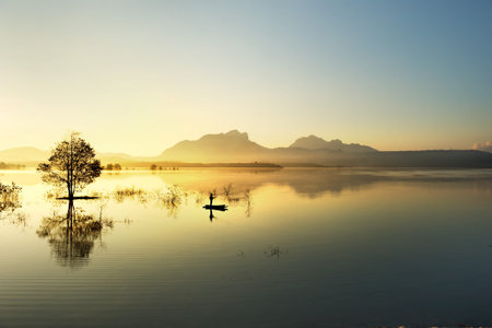 fisherman fishing in big lake ,thailandの写真素材