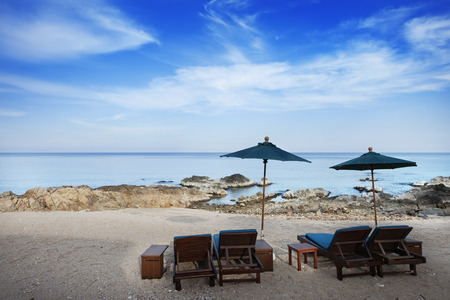 wood chairs with umbrella on beachの写真素材