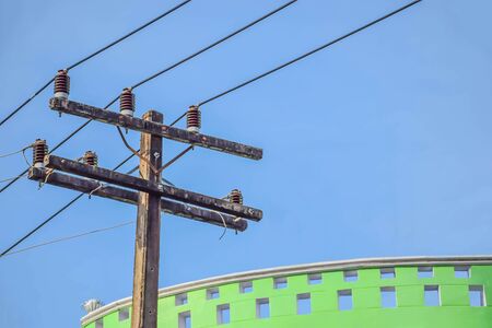 The old high voltage tower, electric wire pole pattern and the concrete wall with the beautiful blue sky cloud in Thailand.の写真素材