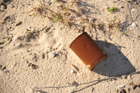 Rusty can trash on the beachの写真素材
