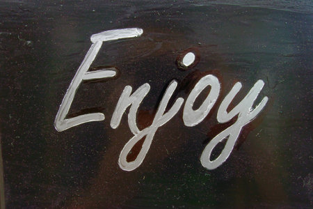 white word enjoy on black backgroundの写真素材