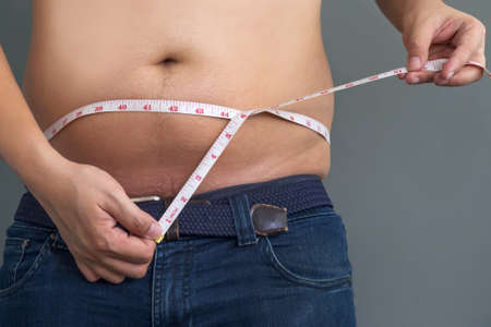 big belly man with measuring tapeの写真素材