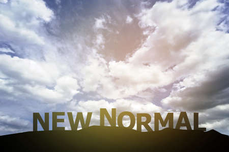 Silhouette new normal text on the mountain in the morning skyの写真素材