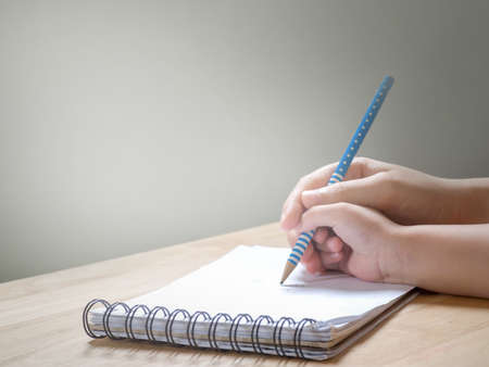 Adult hand holding child hand to writing on notebook.Concept of learning,teaching and practiceの写真素材