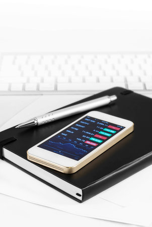 investment stock on mobile on deskの写真素材