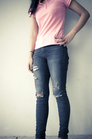 Young fashion woman legs in jeans, vintage tone backgroundの写真素材