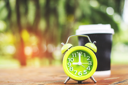 Coffee cup on the table with alarm clock vintage style colorの写真素材