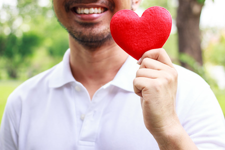 Red heart in man hands, close up on man handの写真素材