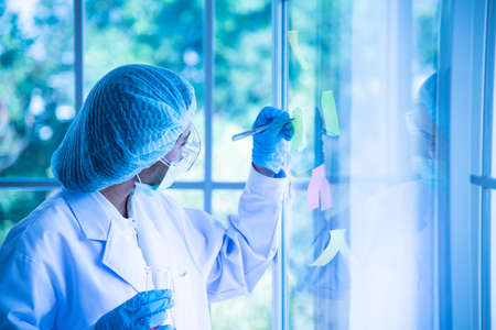 Young women Asian scientist is testing and experimenting with biology to find a vaccine to kill the virus.の写真素材