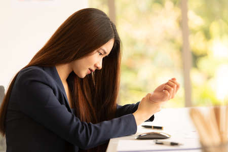 Asian business woman holding her wrist pain from working and using computer. Office syndromeの写真素材