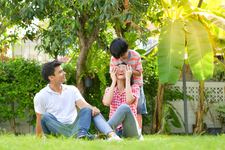 A happy young family spends time playing together in the garden at the front of house the vacation.