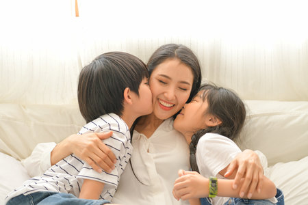 Family happy moments when children wake up in the morning. Have fun with mom before eating breakfast.の写真素材
