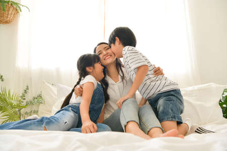 Family happy moments when children wake up in the morning. Have fun with mom before eating breakfast.の写真素材
