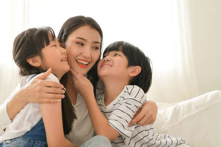Family happy moments when children wake up in the morning. Have fun with mom before eating breakfast.の写真素材