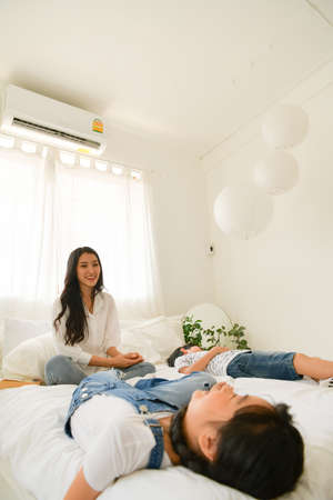 Family happy moments when children wake up in the morning. Have fun with mom before eating breakfast.の写真素材