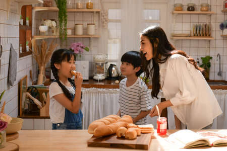 Family happy moments when children Helping mom cook food in the kitchen.の写真素材