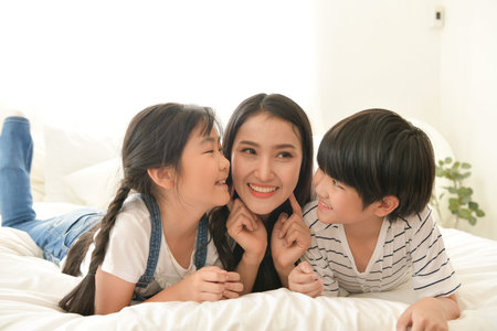 Family happy moments when children wake up in the morning. Have fun with mom before eating breakfast.の写真素材
