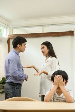 A sad girl who endured listening to her parents arguing in house.の写真素材