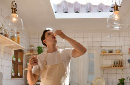 The young man is choosing whether to eat a healthy salad or bread.の写真素材