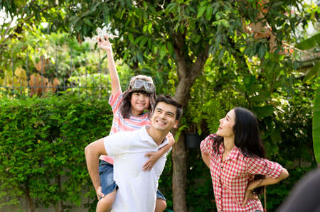 A happy young family spends time playing together in the garden at the front of house the vacation.の写真素材