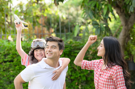 A happy young family spends time playing together in the garden at the front of house the vacation.の写真素材