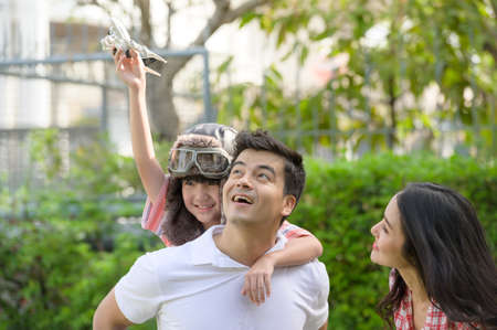 A happy young family spends time playing together in the garden at the front of house the vacation.の写真素材