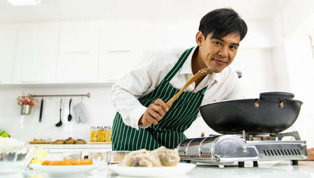 Young asian chef cooking fried rice in kitchenの写真素材