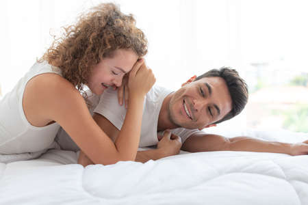Happy couples relaxing in the white bedroom Of the apartment With various emotionsの写真素材