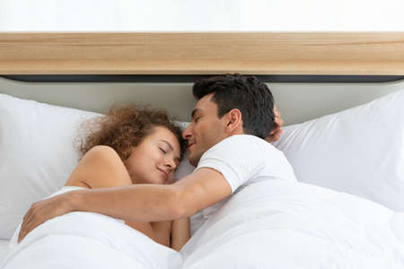 Happy couples relaxing in the white bedroom Of the apartment With various emotionsの写真素材