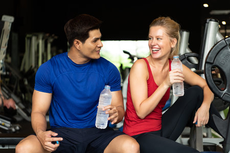 Young couples work out at the gym to strengthen the body. Each person recommends exercise for each...