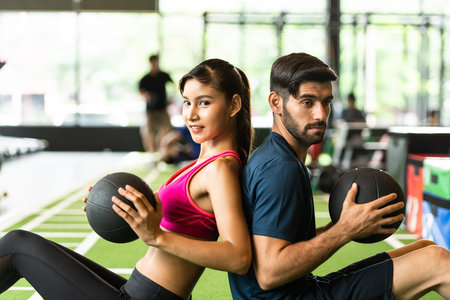Young couples work out at the gym to strengthen the body. Each person recommends exercise for each...