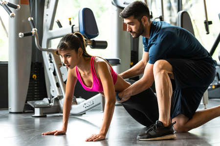 Young couples work out at the gym to strengthen the body. Each person recommends exercise for each other and encourage each other while exercising.の写真素材