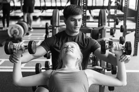 Young couples work out at the gym to strengthen the body. Each person recommends exercise for each...