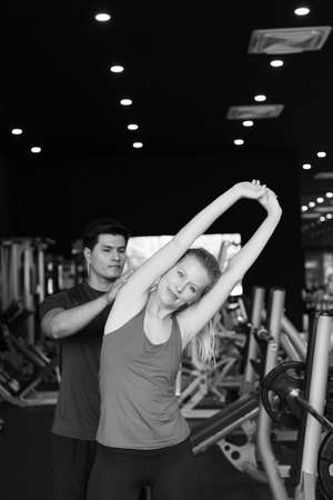 Young couples work out at the gym to strengthen the body. Each person recommends exercise for each other and encourage each other while exercising.の写真素材