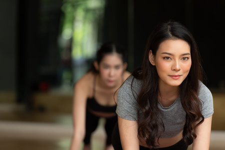 Yoga class of young people interested in yoga activities With a yoga teacher who helps teach yoga postures to students In order to be physically strong and flexible.の写真素材
