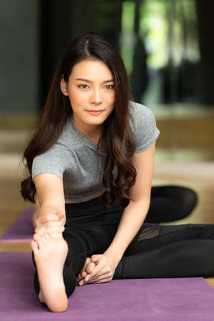 Yoga class of young people interested in yoga activities With a yoga teacher who helps teach yoga postures to students In order to be physically strong and flexible.の写真素材