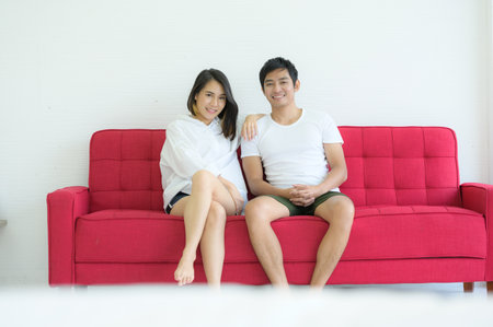 Couples are happy to relax in the white bedroom and share love with each other.の写真素材