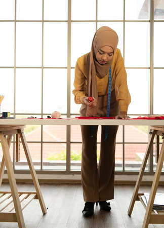 Muslim women run a small business in their own homes. Is the design and tailoring of clothes.の写真素材