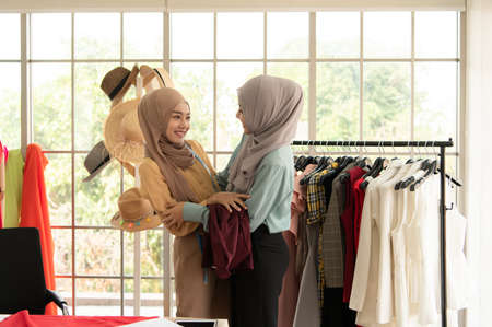 Both Muslim women run a small business in their own homes. Is the design and tailoring of clothes.の写真素材