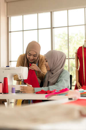 Both Muslim women run a small business in their own homes. Is the design and tailoring of clothes.の写真素材