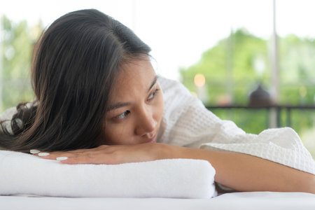 Portrait of young beautiful asian woman enjoys massage in a luxury spa resort