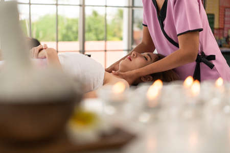 Portrait of young beautiful asian woman enjoys massage in a luxury spa resortの写真素材