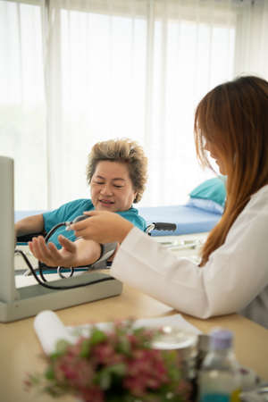 Female doctors perform disease tests and provide medical advice to senior patients that treatment.の写真素材