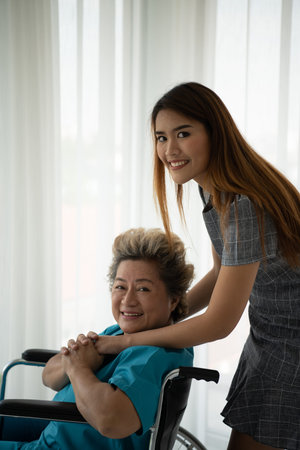 Daughter of a senior patient taking care and encouraging the mother after receiving treatment from...