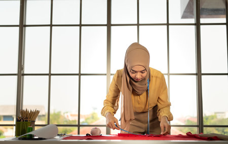 Muslim women run a small business in their own homes. Is the design and tailoring of clothes.の写真素材