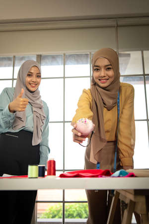 Muslim women run a small business in their own homes. Is the design and tailoring of clothes.の写真素材