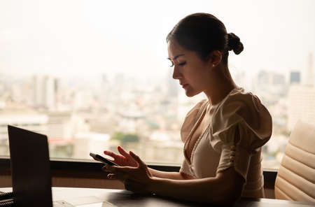 A young businesswoman who travels all over the world to do business. must stay and live in a hotel as a place to relax and sleep as well as used as a workplaceの写真素材