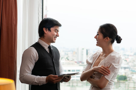 A young businessman monitors and keeps track of tasks in his office with a cityscape in the...