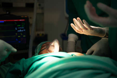 Professor of medicine in cardiology and a team of doctors in the operating room undergoing heart transplant surgeryの写真素材