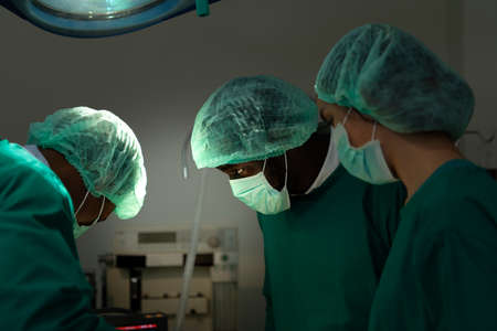 Professor of medicine in cardiology and a team of doctors in the operating room undergoing heart transplant surgeryの写真素材